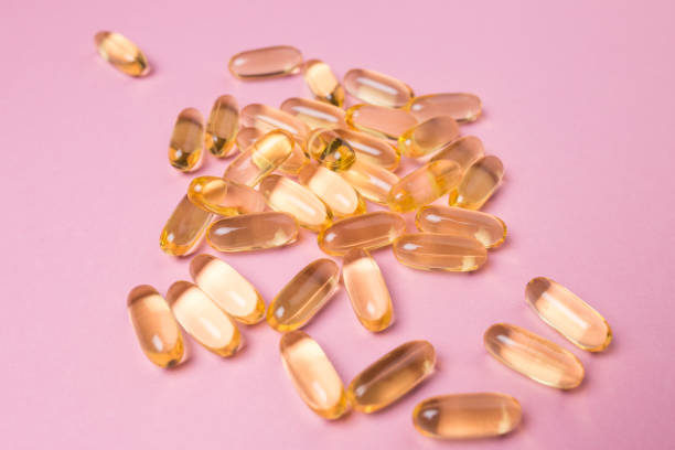 istock Close up vitamin C capsules on pink isolated background 1261173832