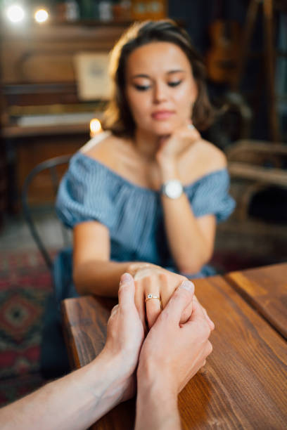 istock male hands holding female hand with wedding ring on finger. 1261217101