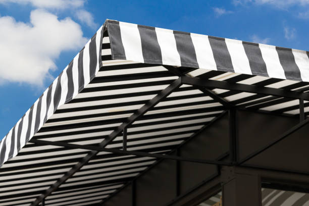 istock black and white striped awning with blue sky. 1261231499