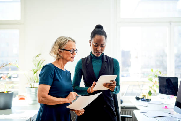 istock Coworkers discussing over digital tablet in office 1261232016