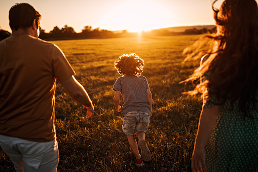 Happy family walking in sunset