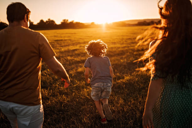 We are always together Happy family walking in sunset wide field stock pictures, royalty-free photos & images