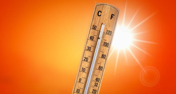 Thermometer against orange background with hot summer sun. Heat wave concept. Wooden thermometer showing high temperatures around 40 degrees Celsius or 104 degrees Fahrenheit on sunny red orange sky background. Copy space. hyperthermia photos stock pictures, royalty-free photos & images