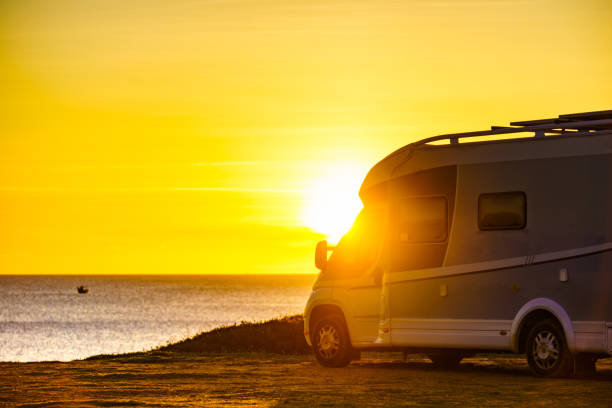 istock Camper car on beach at sunrise 1261270576