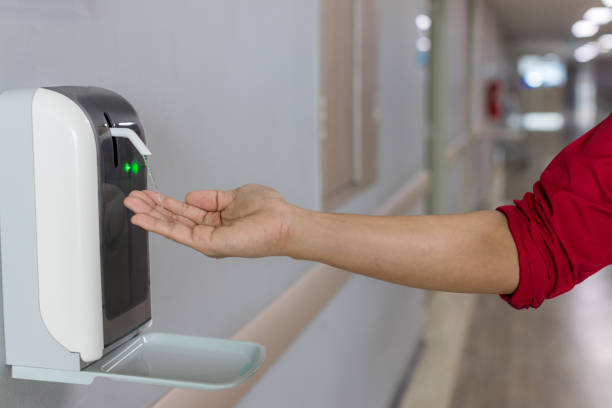 istock Hands under the automatic alcohol dispenser. Infection and hospitably concept. save and protect disease virus against germs and clean in the public area. 1261283789
