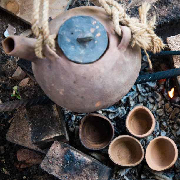 istock A steaming teapot and tea cups. Tea preparation in a clay pot on a fire. A camping trip, a journey. 1261330427