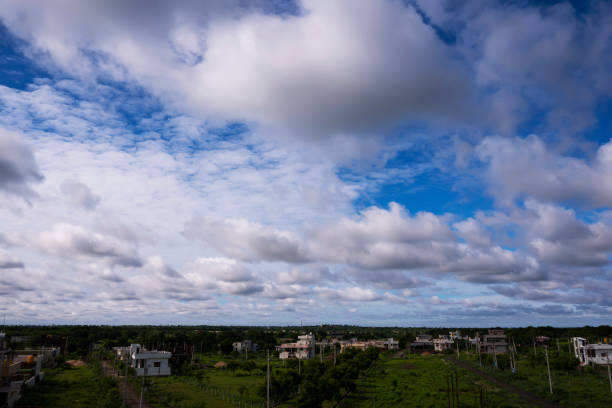 istock cityscape with blue sky, clouds & green land 1261332580