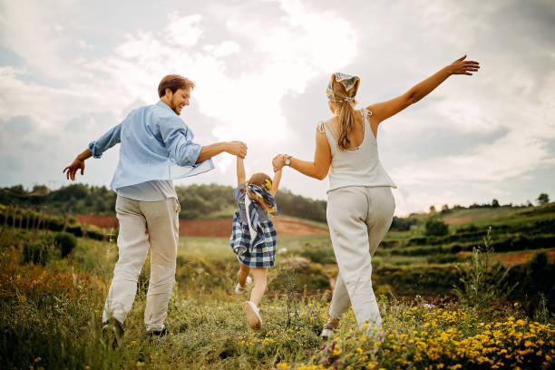 istock Kid walking in meadow with parents 1261348275