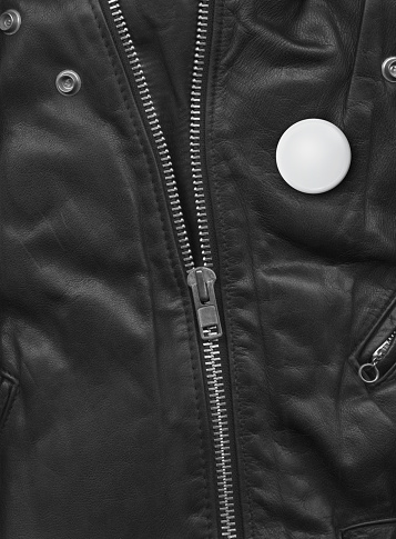 Badge on a Black leather jacket close-up view. Texture Background