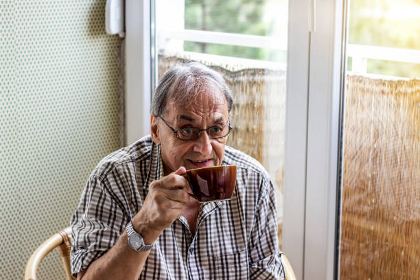istock An old man inside the house,holding and drinking a cup of tea. 1261361202