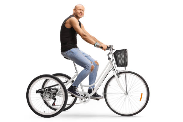 istock Bald hipster man riding a tricycle and looking at the camera 1261371413