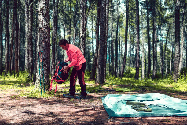istock Senior Camper Getting Ready To Make Tent In Forest 1261373029