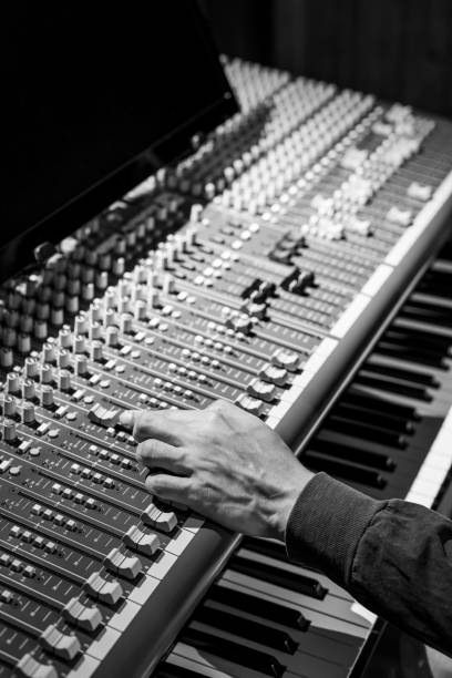 istock sound engineer hand adjusting level fader on audio mixing console in studio 1261374630