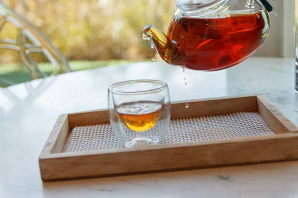 istock Hot green tea is poured from the kettle into a small cup 1261407804