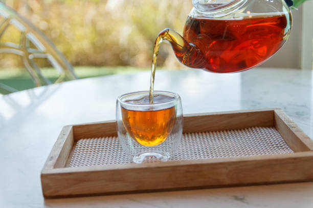 istock Hot green tea is poured from the kettle into a small cup 1261408348