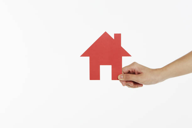 istock Human hand holding a cut out house 1261408355