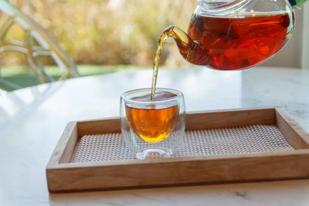 istock Hot green tea is poured from the kettle into a small cup 1261408703