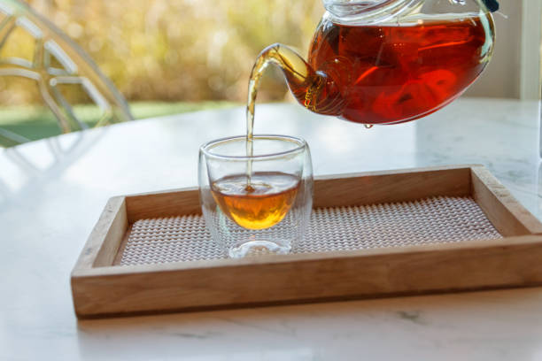 istock Hot green tea is poured from the kettle into a small cup 1261408868