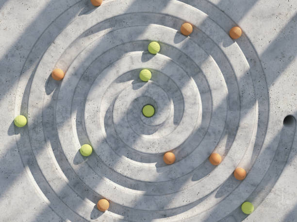 A spiral is cut through the floor, from which small colored balls roll and fall into the hole in the center