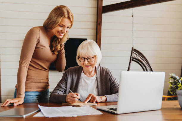 istock Beauty middle aged lady teaching her mom to use computer 1261421366