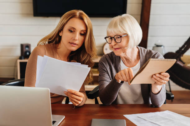 istock Caucasian woman explaining some documentation or bill papers to parent at home 1261422495