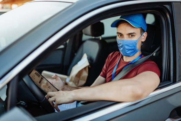 istock Courier in the vehicle with face mask - delivery during quarantine 1261424120