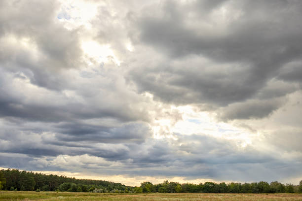 istock Cloudy field with sunshine breaking through the cloud cover 1261424655