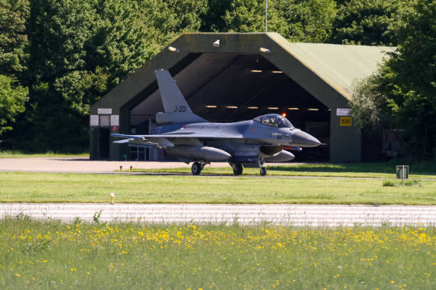 Netherlands Air Force F-16 Fighting Falcon in front of a shelter Leeuwarden, Friesland, Netherland - 11.24.2013 : Netherlands Air Force F-16 Fighting Falcon in front of a shelter during the Nato Fighter Weapon instructor training (FWIT) exercise. supersonic airplane editorial airplane air vehicle stock pictures, royalty-free photos & images