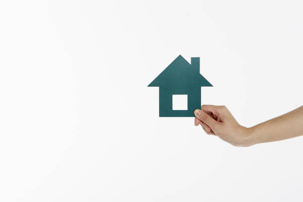 istock Human hand holding a cut out house 1261439514