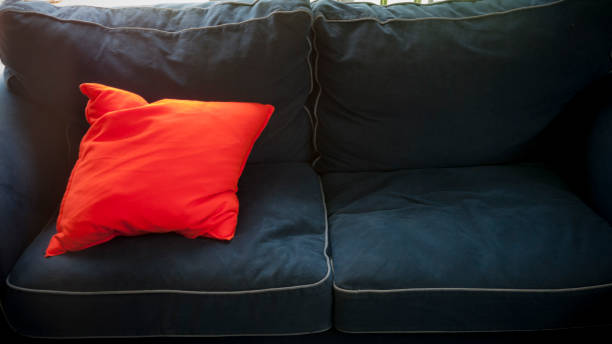 istock Orange fluoride cushion on dark blue sofa 1261448798