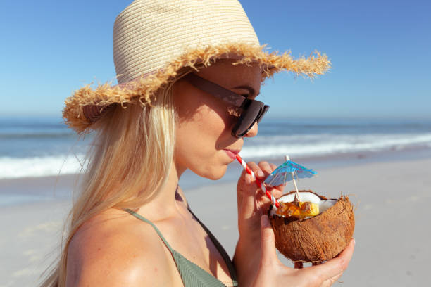istock Woman drinking coconut cocktail on the beach 1261455900