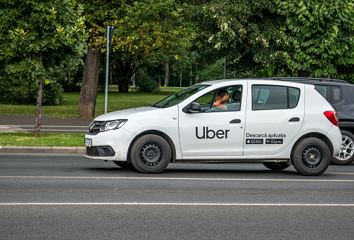Bucharest/Romania - 07.15.2020: Car with the logo of the ride hailing company Uber in traffic.