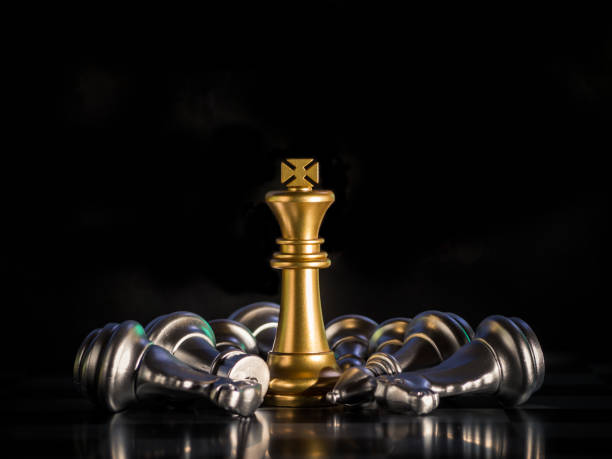 istock Golden king chess is surrounded by falling around silver chess pieces  to fighting with teamwork to victory, business strategy concept and leader and teamwork concept for success. 1261469053