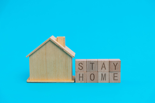 House model and stay home text on blue background.