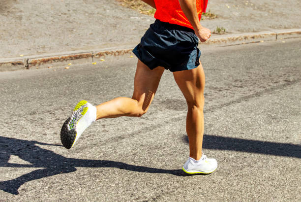 istock male runner running on road in hard light 1261472030