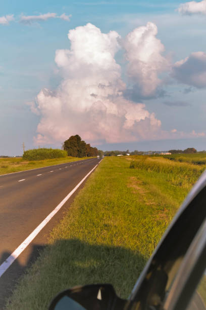 istock Sunset landscape with plain, storm clouds on the road 1261474299
