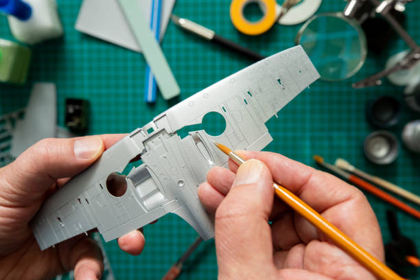 istock Overhead View Of Man Building Scale Model Aeroplane From Kit On Cutting BoardWith Tools And Materials 1261496871