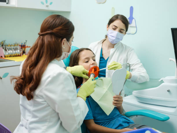 istock Latin dentist and assistant working with protective gloves 1261502354