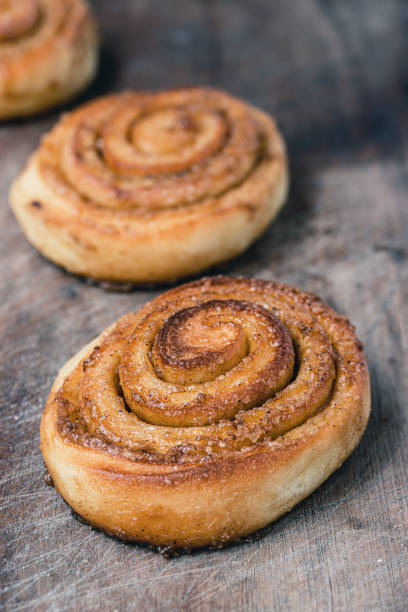 Cinnamon rolls on old wooden background. Copy space