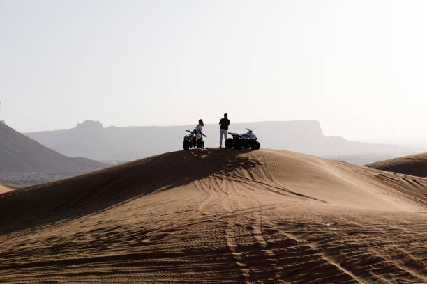 deux jeunes saoudiens prennent une pause dans le désert - off road vehicle quadbike desert dirt road photos et images de collection