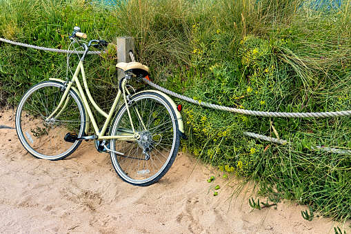 Bicycle parked beside rope fence and wild grass at Fistral Beach, Newquay, Cornwall