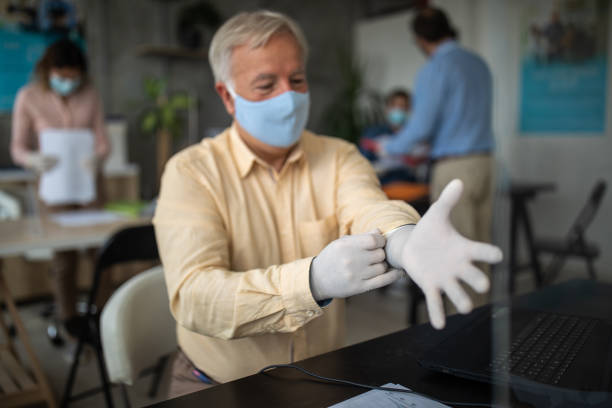 istock Businessman putting on protective gloves at bank office 1261544065