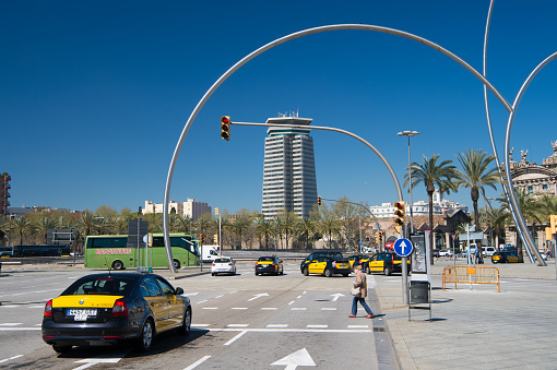 Barcelona, Spain - March 30, 2016: city crossroad and crosswalk with traffic lights. Intersection. Urban road. Town buildings on blue sky. Transportation in traffic jam. Travelling and wanderlust