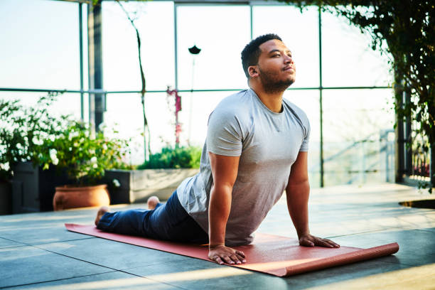 istock Young man practicing the cobra pose in a yoga studio 1261564089