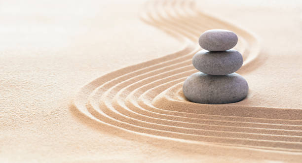 zen steine mit linien auf sand - spa-therapie - reinheit, harmonie und balance-konzept - buddhismus fotos stock-fotos und bilder