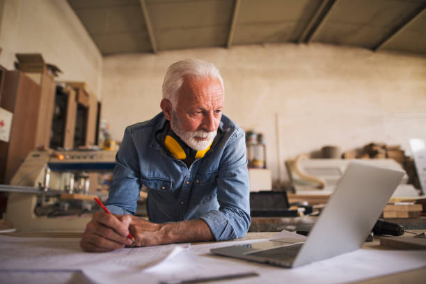 istock Senior architect looking at the laptop 1261570348
