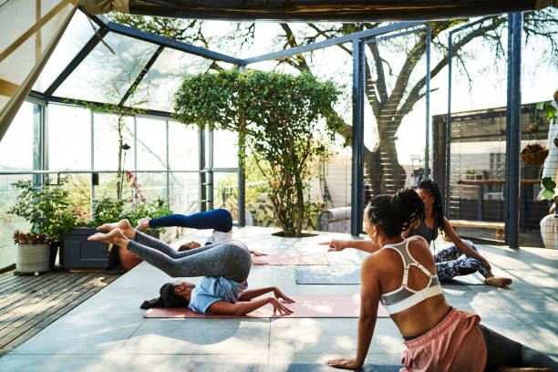istock Teacher helping talking with her students during a yoga class 1261574539