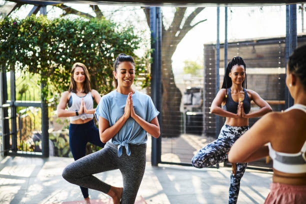 istock Smiling women practicing the tree pose together during a yoga class 1261578576