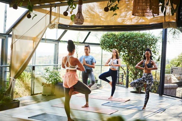 istock Teacher leading her students in the tree pose during a yoga class 1261580789