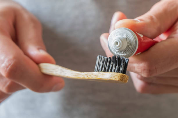 istock Male hands applying toothpaste on eco natural bamboo toothbrush 1261646212